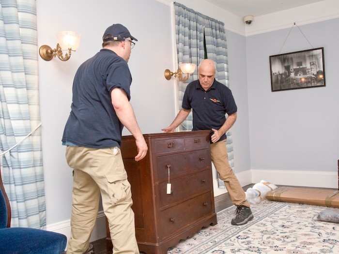 workers from U.S.Art moving a mahogany chest to its proper location in the "Gate room" on the 2nd floor.