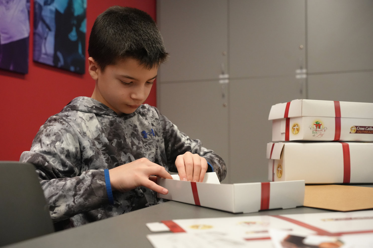 William Shuart, 12, of Bellmore helps fold boxes during the MLK Day of Service event at Molloy University.